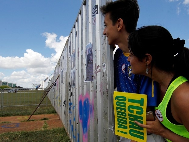 Manifestantes pr impeachment observam o outro lado do muro que dividiu os dois grupos em Braslia, na votao de abril